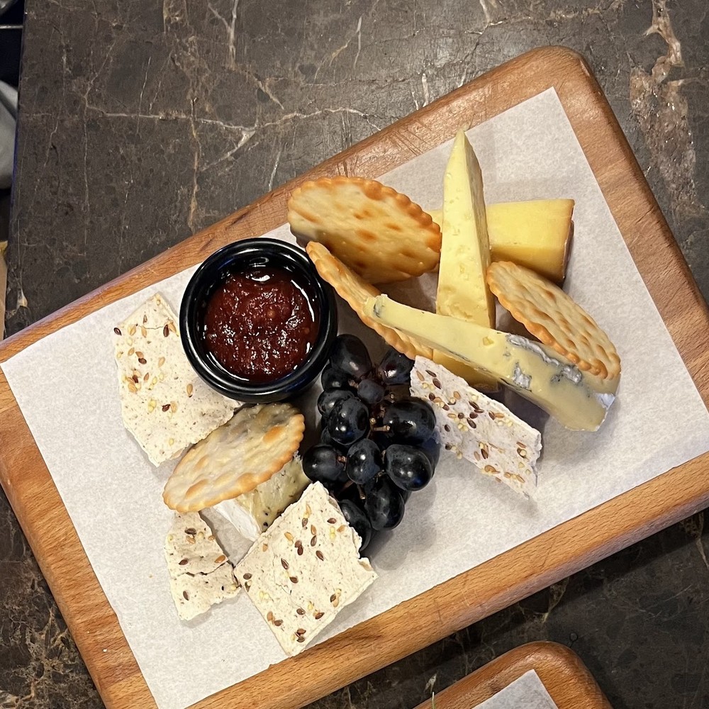 A cheese board with crackers, grapes and chutney at Tram Coffee & Wine