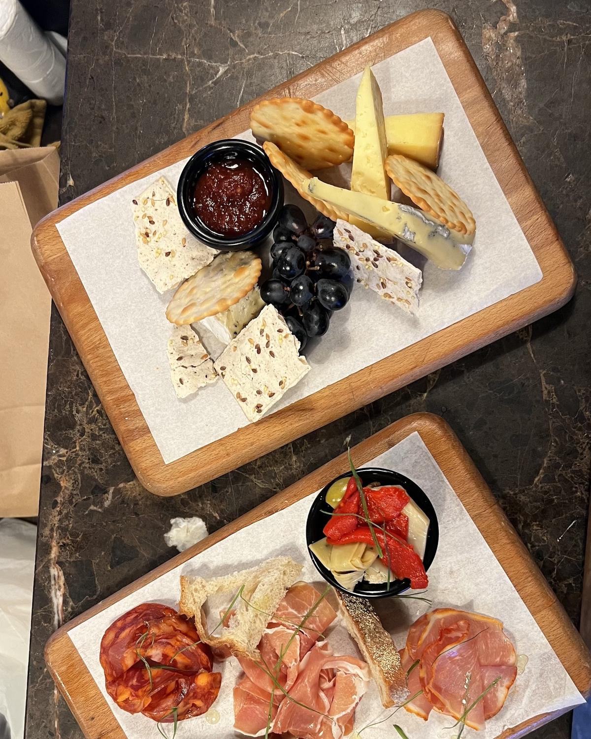A cheese board with crackers, grapes and chutney on a marble counter at Tram Coffee & Wine